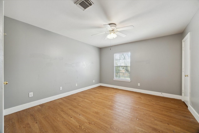 spare room featuring light wood-style floors, visible vents, baseboards, and a ceiling fan