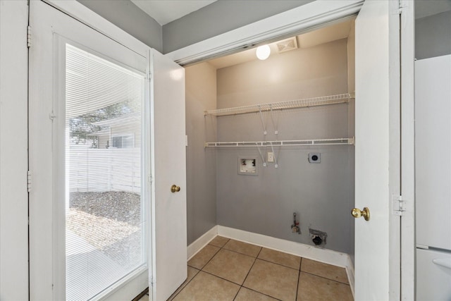 clothes washing area featuring baseboards, hookup for a gas dryer, hookup for a washing machine, hookup for an electric dryer, and light tile patterned flooring