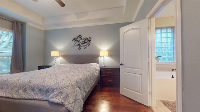 bedroom with ornamental molding, dark wood-style flooring, a raised ceiling, and a ceiling fan