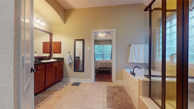 ensuite bathroom with a garden tub, connected bathroom, vanity, baseboards, and tile patterned floors