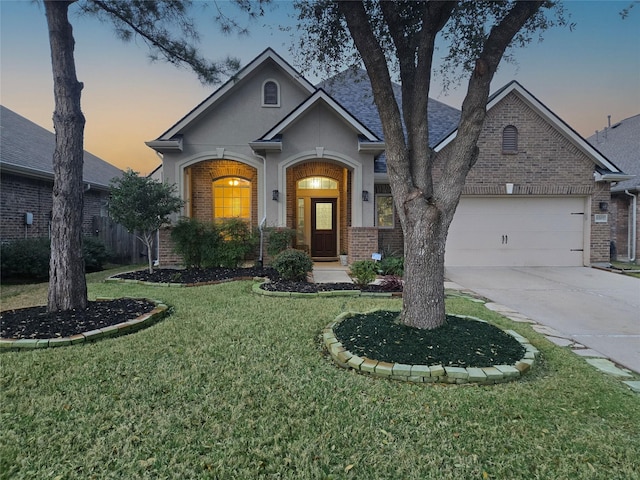 view of front facade with a garage, concrete driveway, brick siding, and a front yard