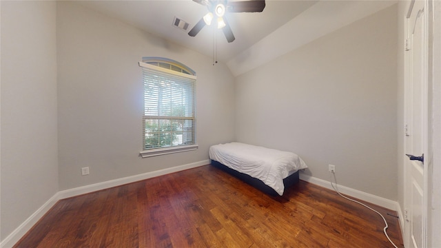 bedroom featuring baseboards, visible vents, ceiling fan, wood finished floors, and vaulted ceiling