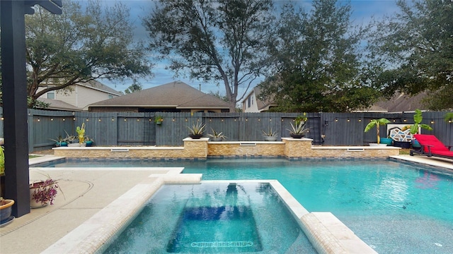 view of swimming pool with a pool with connected hot tub and a fenced backyard