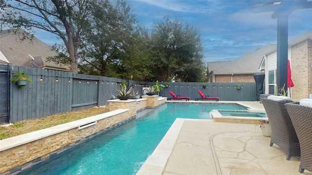 view of pool featuring a patio area, a fenced backyard, and a pool with connected hot tub