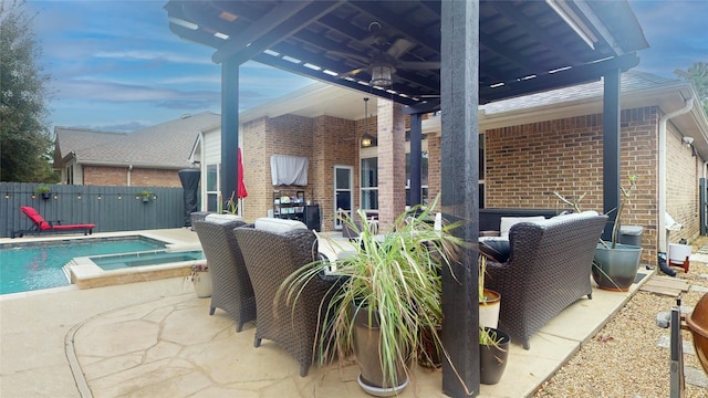 view of patio with a pool with connected hot tub and fence