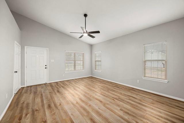 unfurnished room featuring lofted ceiling, plenty of natural light, light wood-style flooring, and a ceiling fan