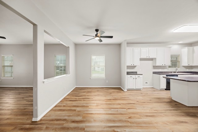 kitchen with ceiling fan, white cabinetry, light wood-style floors, dishwasher, and dark countertops