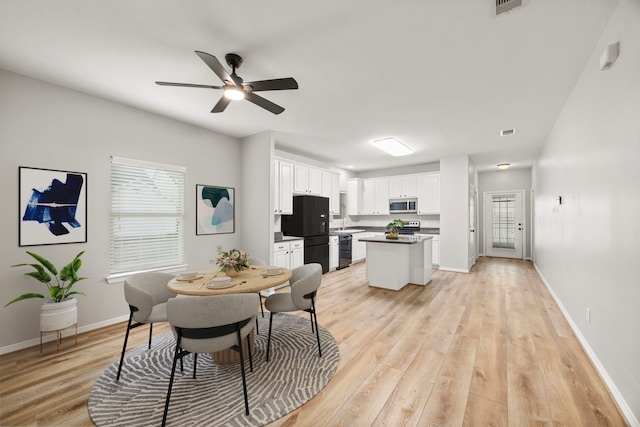 dining area featuring ceiling fan, visible vents, light wood-style flooring, and baseboards