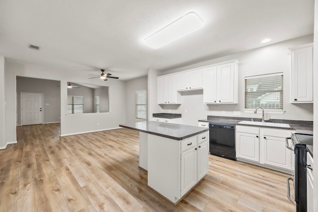 kitchen with range with electric cooktop, a sink, visible vents, black dishwasher, and dark countertops