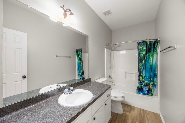 full bathroom with visible vents, toilet, shower / tub combo with curtain, wood finished floors, and vanity