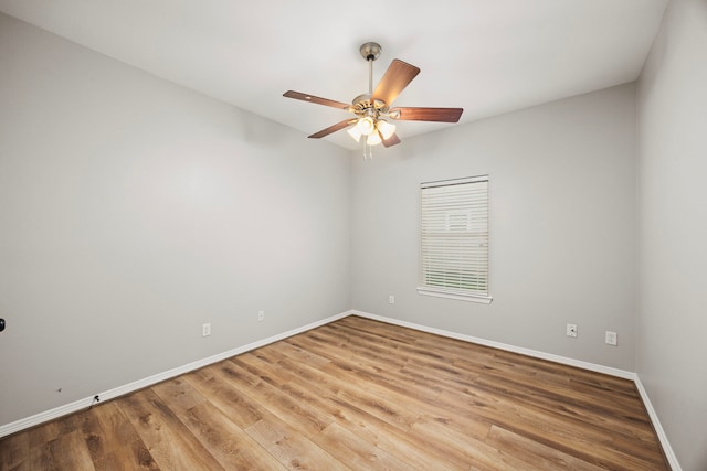 unfurnished room with wood finished floors, a ceiling fan, and baseboards