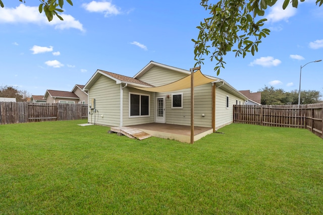 rear view of house with a patio area, a fenced backyard, and a lawn