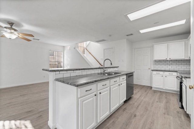 kitchen with appliances with stainless steel finishes, light wood-type flooring, a sink, and visible vents