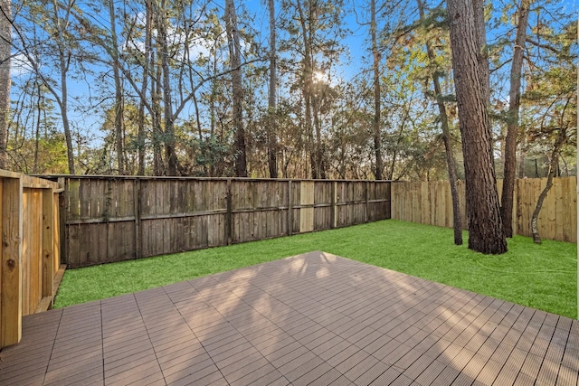 wooden deck featuring a fenced backyard and a yard