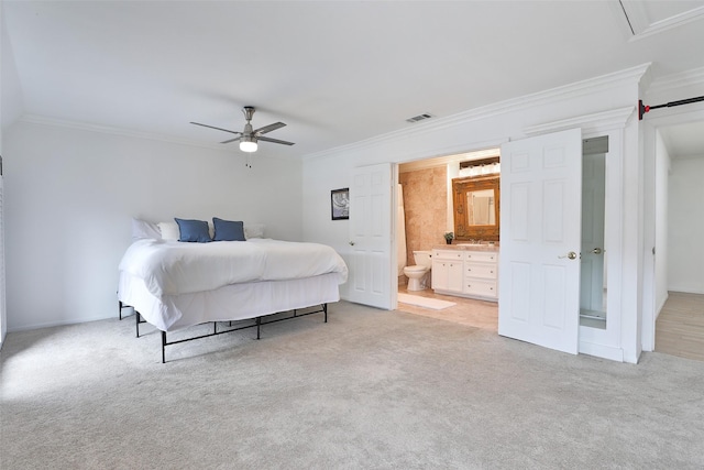 bedroom featuring ensuite bathroom, light colored carpet, a ceiling fan, visible vents, and crown molding