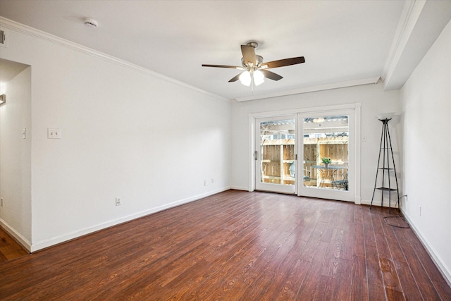 empty room featuring ornamental molding, dark wood-style flooring, and baseboards