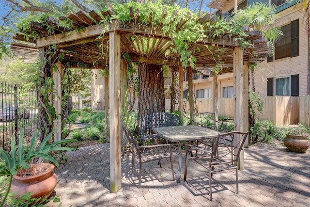 view of patio featuring outdoor dining space and fence