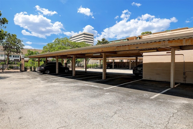 covered parking lot featuring fence