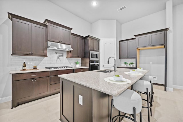 kitchen with tasteful backsplash, visible vents, appliances with stainless steel finishes, a sink, and under cabinet range hood