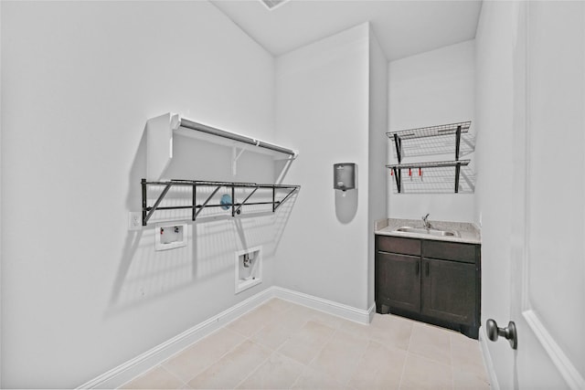 washroom featuring light tile patterned floors, hookup for a washing machine, a sink, baseboards, and electric dryer hookup