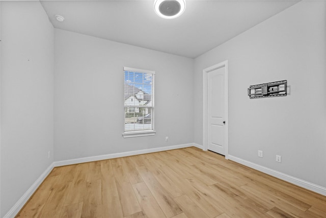 spare room featuring light wood finished floors and baseboards