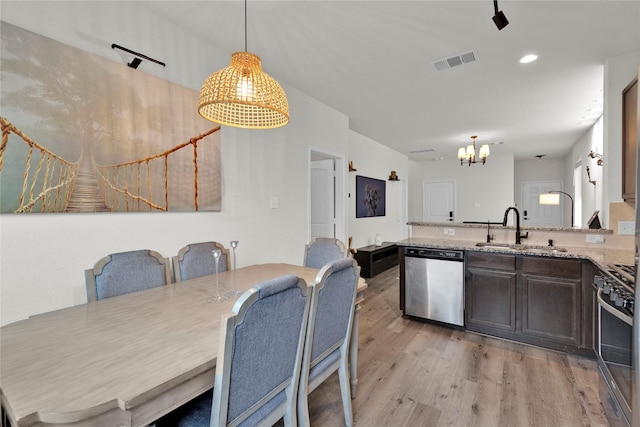 kitchen featuring light wood-style flooring, a sink, visible vents, appliances with stainless steel finishes, and light stone countertops