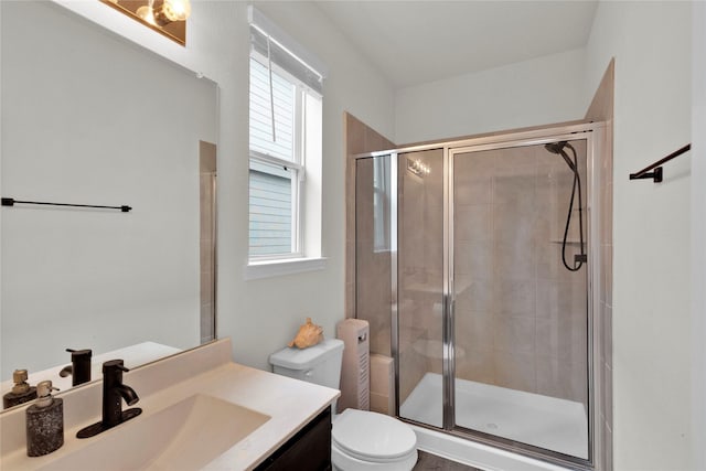 bathroom with a stall shower, vanity, and toilet