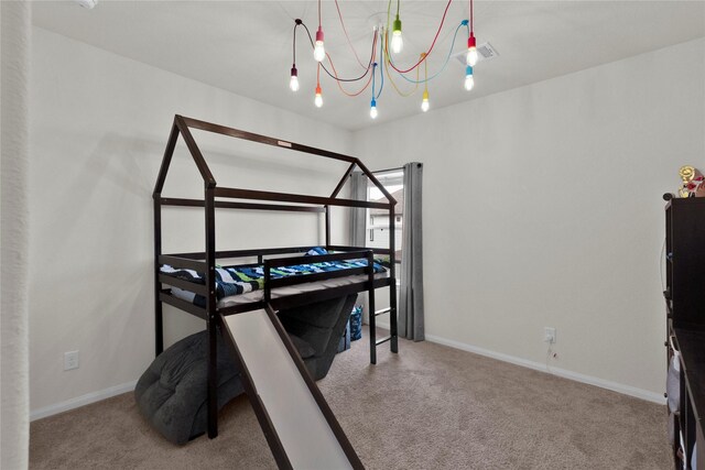 carpeted bedroom with visible vents, baseboards, and an inviting chandelier