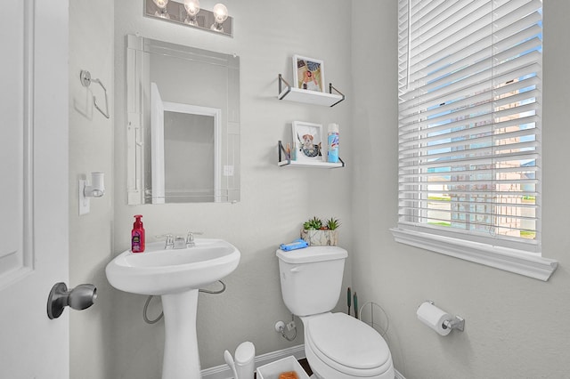 bathroom featuring toilet and baseboards