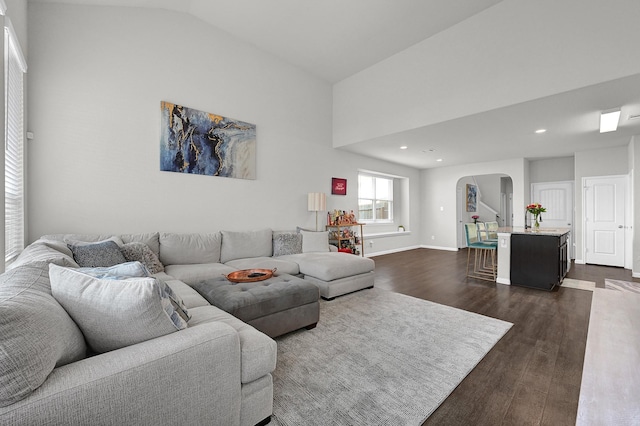 living area with arched walkways, lofted ceiling, recessed lighting, dark wood-type flooring, and baseboards