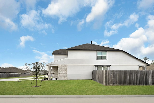 view of home's exterior featuring brick siding, fence, and a yard