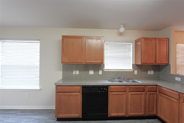 kitchen with a sink, baseboards, light countertops, backsplash, and dishwasher