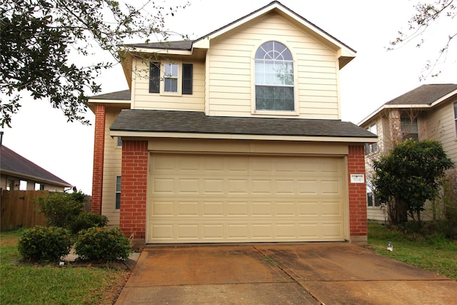 traditional-style house featuring brick siding, driveway, an attached garage, and roof with shingles