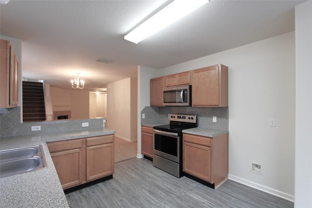 kitchen featuring backsplash, stainless steel appliances, a sink, and light countertops