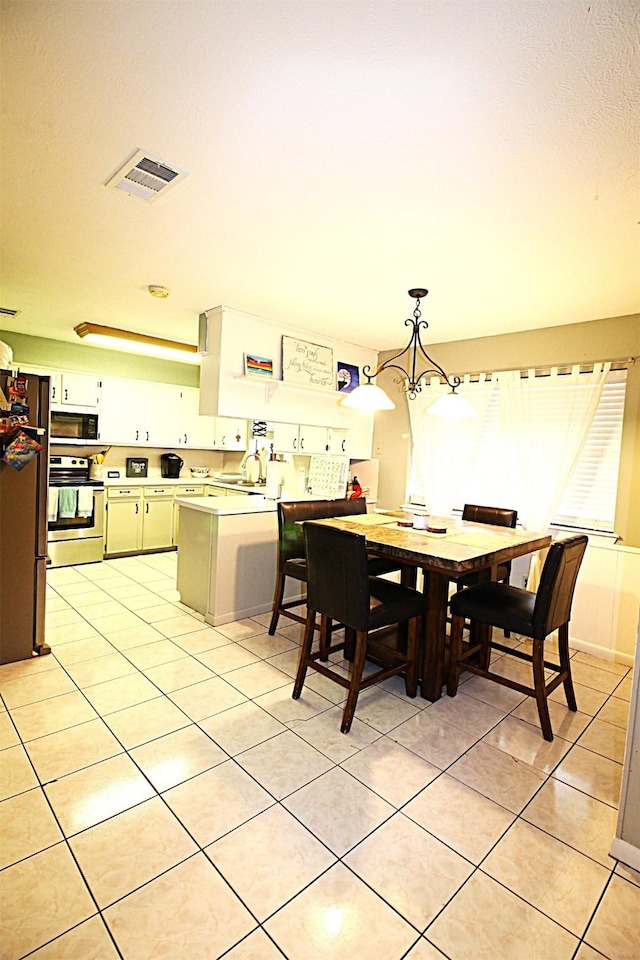 dining space featuring light tile patterned floors, visible vents, and a notable chandelier