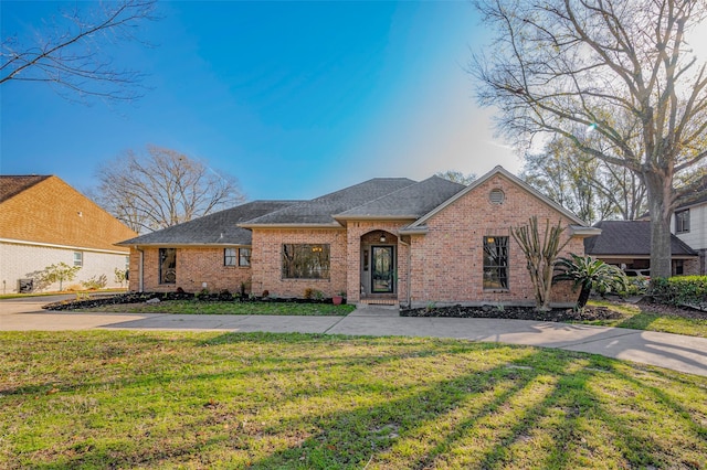 view of front of house featuring a front lawn, concrete driveway, and brick siding