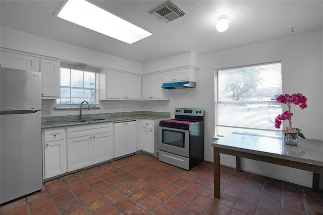 kitchen featuring under cabinet range hood, stainless steel appliances, a sink, visible vents, and white cabinets