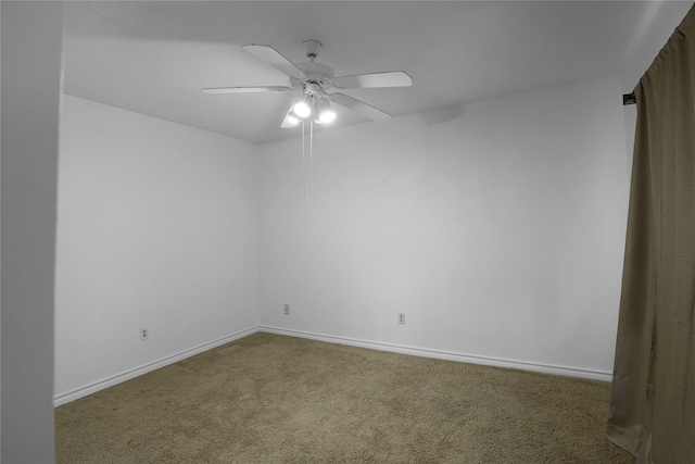 carpeted empty room with a ceiling fan and baseboards