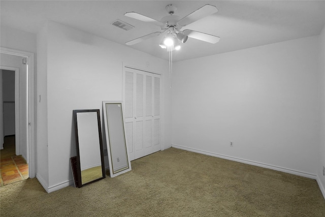 unfurnished bedroom with baseboards, visible vents, ceiling fan, carpet floors, and a closet