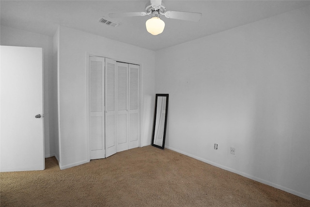 unfurnished bedroom featuring carpet flooring, visible vents, baseboards, a ceiling fan, and a closet