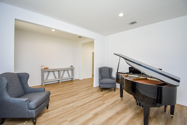 living area with light wood-type flooring, visible vents, and recessed lighting