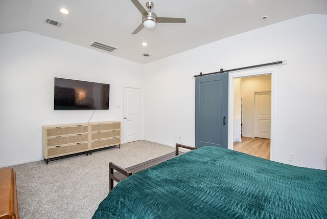 bedroom featuring recessed lighting, visible vents, vaulted ceiling, and a barn door