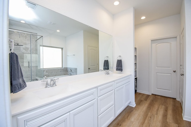 full bathroom featuring a stall shower, visible vents, a sink, and a garden tub