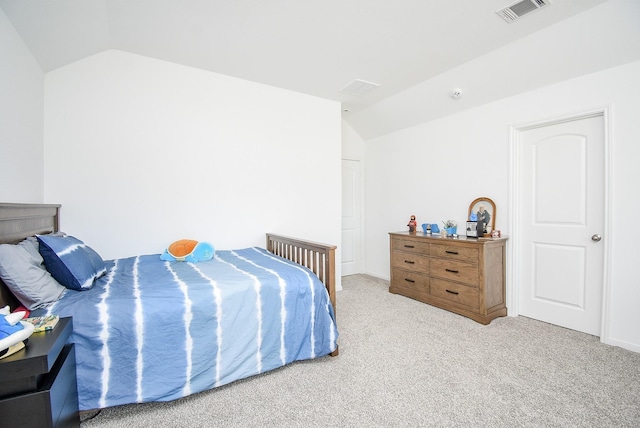 bedroom with vaulted ceiling, carpet floors, and visible vents