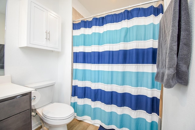 bathroom with vanity, wood finished floors, toilet, and a shower with curtain