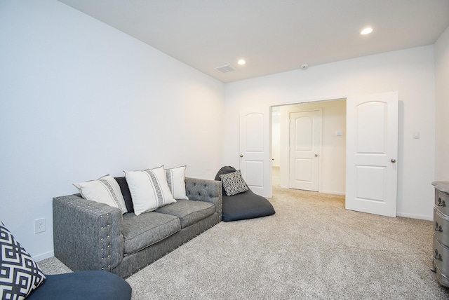 living area featuring baseboards, recessed lighting, visible vents, and light colored carpet