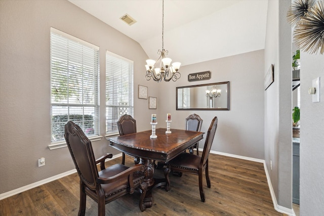 dining space with visible vents, vaulted ceiling, wood finished floors, a chandelier, and baseboards