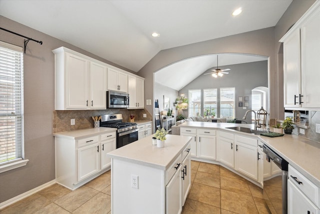 kitchen with tasteful backsplash, lofted ceiling, ceiling fan, appliances with stainless steel finishes, and light countertops