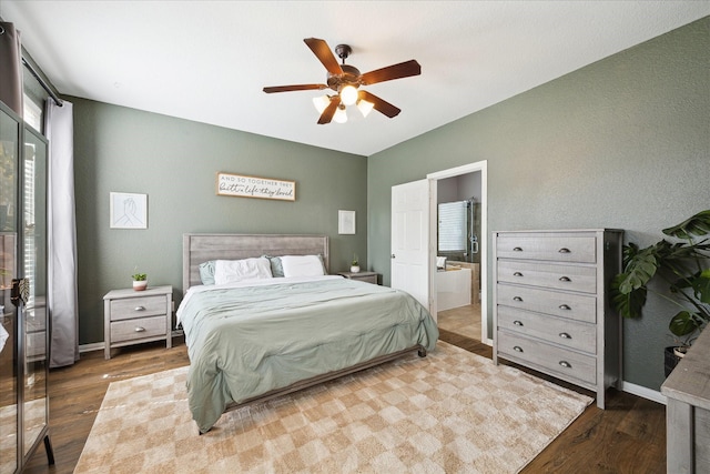 bedroom featuring ensuite bathroom, wood finished floors, a ceiling fan, and baseboards