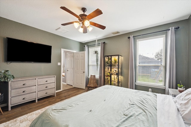 bedroom featuring dark wood-style flooring, visible vents, and ceiling fan